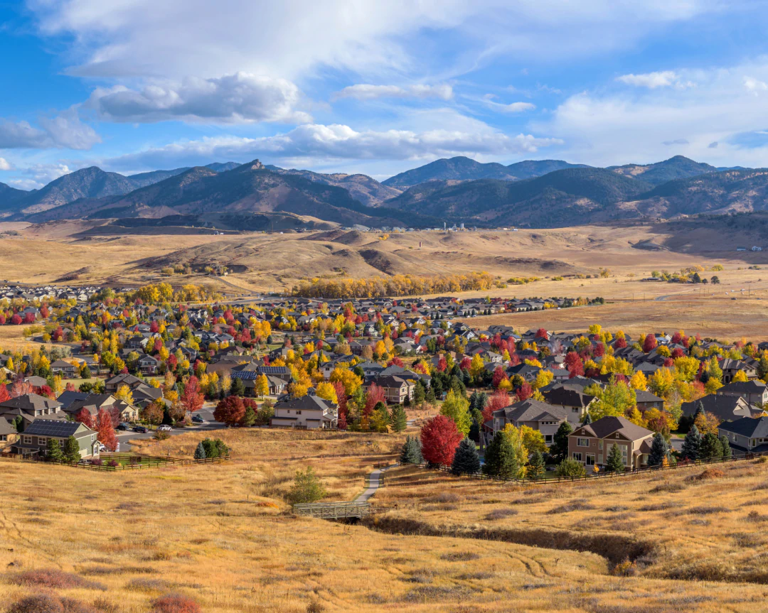 Mobile_Contact_Us_From_Olde_Town A suburban neighborhood with autumn-colored trees sits at the base of a large mountain range.